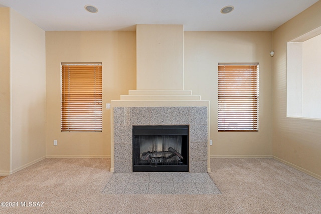 room details featuring a tiled fireplace and carpet flooring