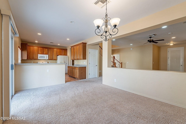 kitchen featuring light carpet, white appliances, kitchen peninsula, pendant lighting, and ceiling fan with notable chandelier