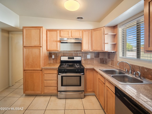 kitchen featuring stainless steel appliances, backsplash, sink, vaulted ceiling, and light tile patterned floors