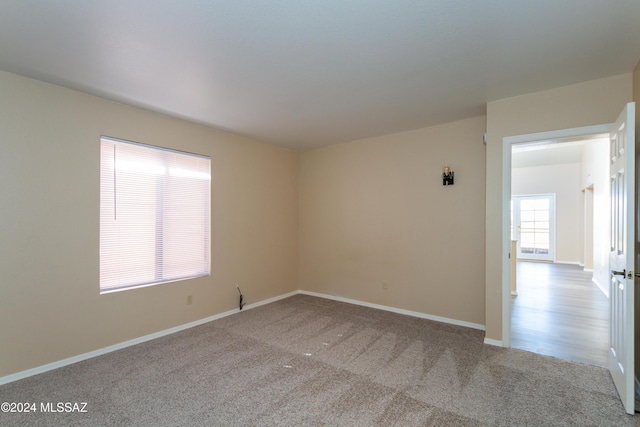 carpeted empty room featuring baseboards