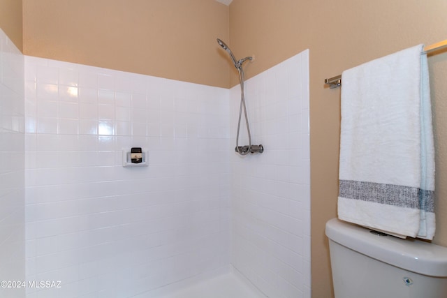 full bathroom featuring toilet and tiled shower