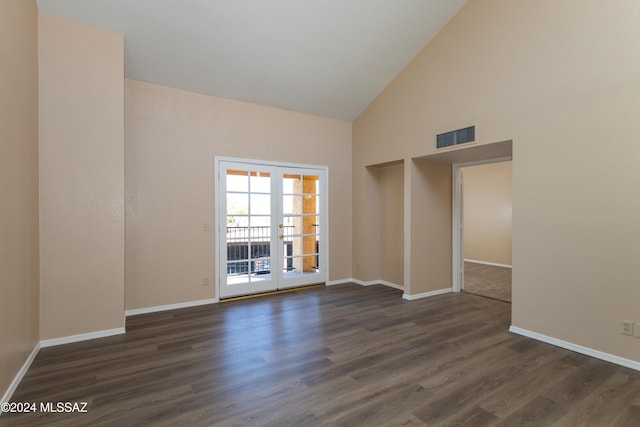 unfurnished room with visible vents, baseboards, high vaulted ceiling, and dark wood finished floors