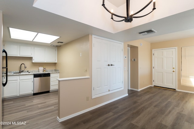 kitchen featuring visible vents, light countertops, dark wood-style flooring, stainless steel dishwasher, and a sink