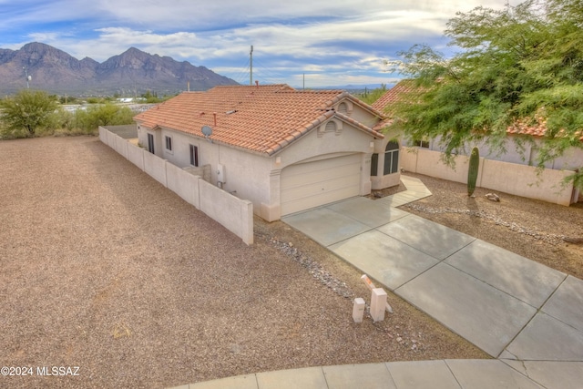 view of front of home featuring a garage, concrete driveway, a tiled roof, fence, and stucco siding