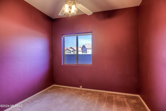 empty room featuring carpet floors, baseboards, and a ceiling fan