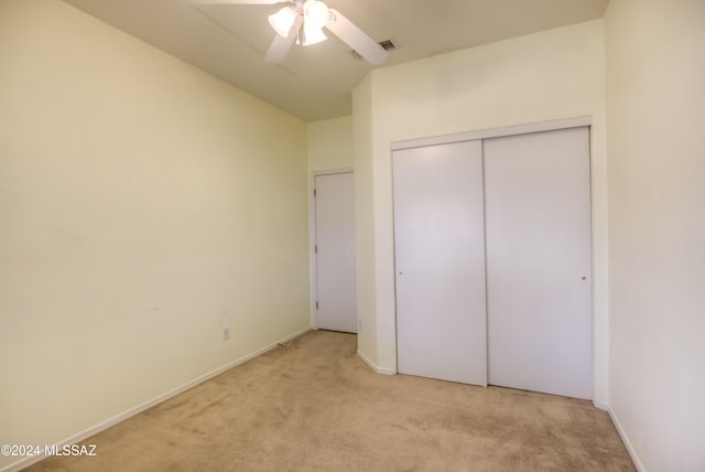 unfurnished bedroom with light carpet, visible vents, baseboards, ceiling fan, and a closet