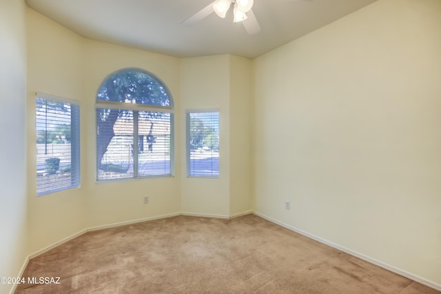 spare room with carpet, a ceiling fan, and baseboards