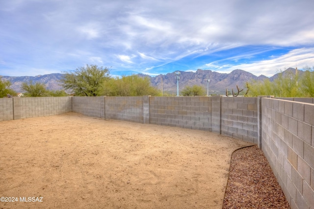 view of yard featuring a fenced backyard and a mountain view