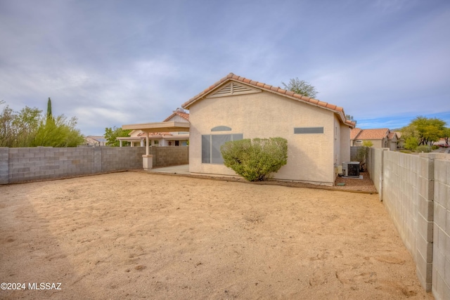 back of property featuring central air condition unit, a tile roof, a fenced backyard, and stucco siding