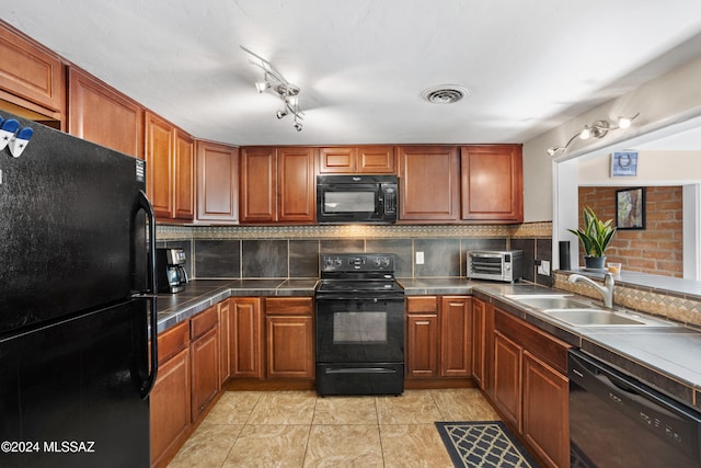 kitchen featuring sink, black appliances, backsplash, and light tile patterned floors