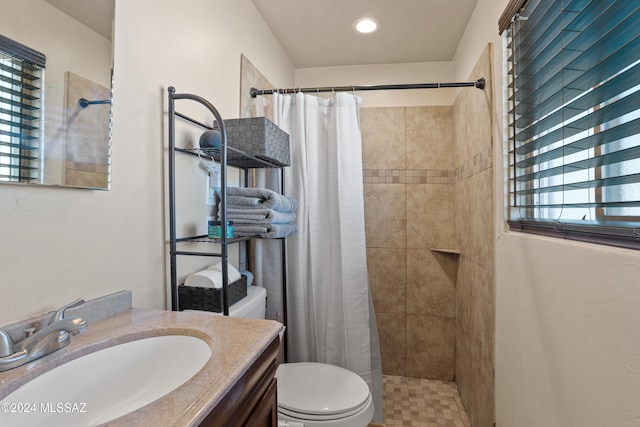 bathroom featuring toilet, walk in shower, and vanity