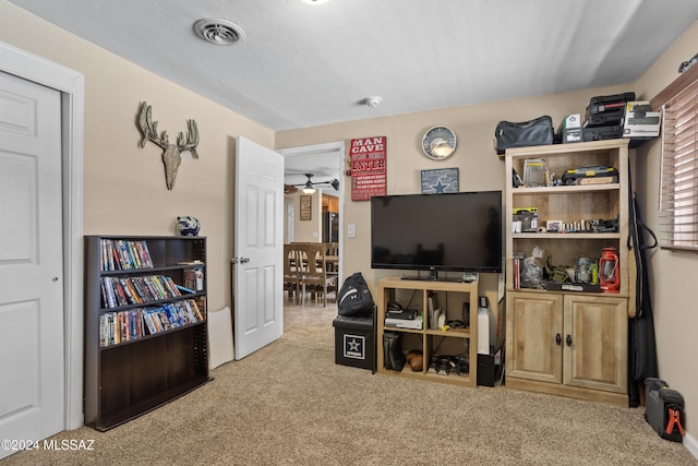 interior space with ceiling fan and light colored carpet