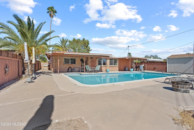 view of pool with a patio and a storage unit