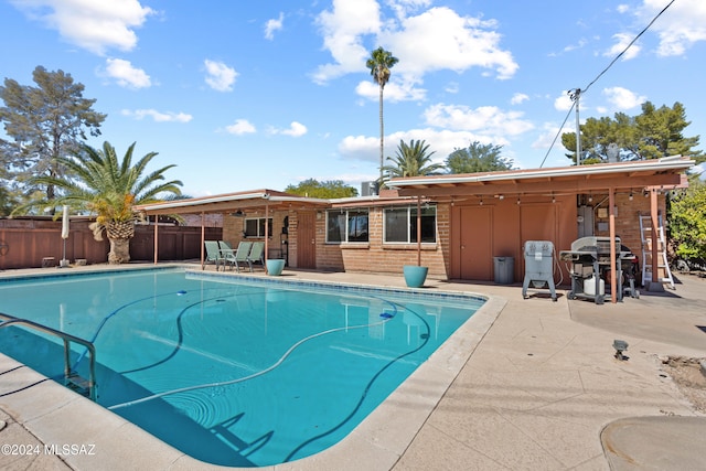 view of pool with a patio area and a grill