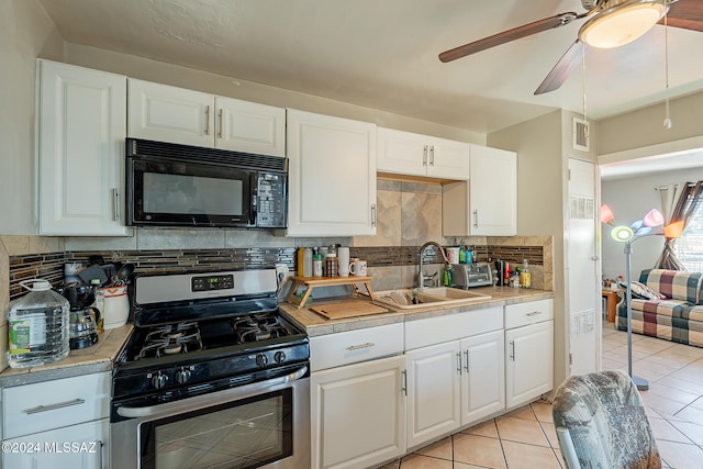 kitchen with stainless steel range with gas stovetop, backsplash, white cabinetry, and sink