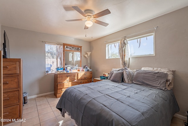 tiled bedroom featuring ceiling fan and multiple windows