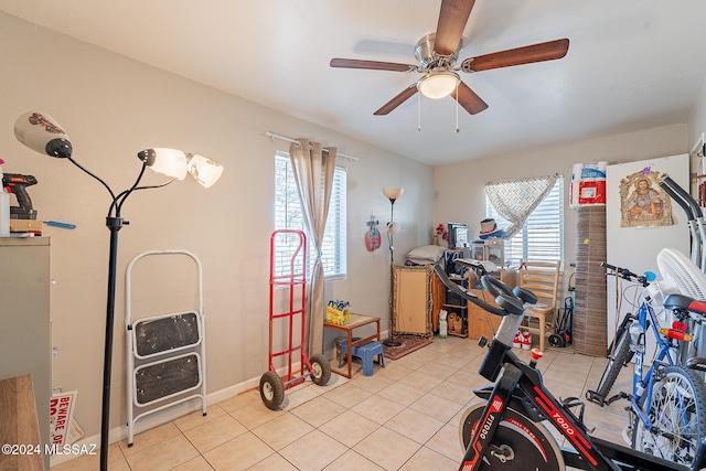 exercise area featuring ceiling fan and light tile patterned floors