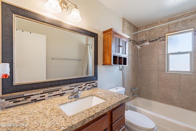 full bathroom featuring toilet, decorative backsplash, vanity, and shower / tub combo