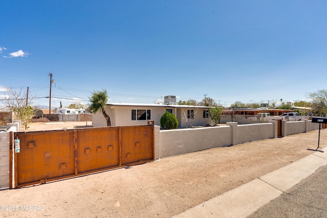 view of front of home with a fenced front yard and a gate