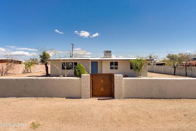 view of front of house featuring a gate, a fenced front yard, and stucco siding
