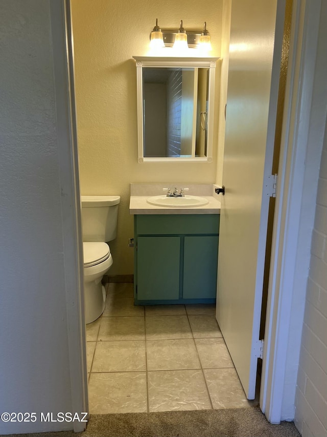 bathroom with tile patterned flooring, vanity, and toilet