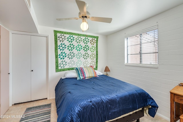 bedroom featuring light tile patterned floors, a closet, and ceiling fan