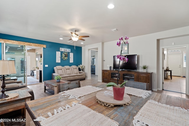 living room with light hardwood / wood-style flooring, ceiling fan, and a healthy amount of sunlight