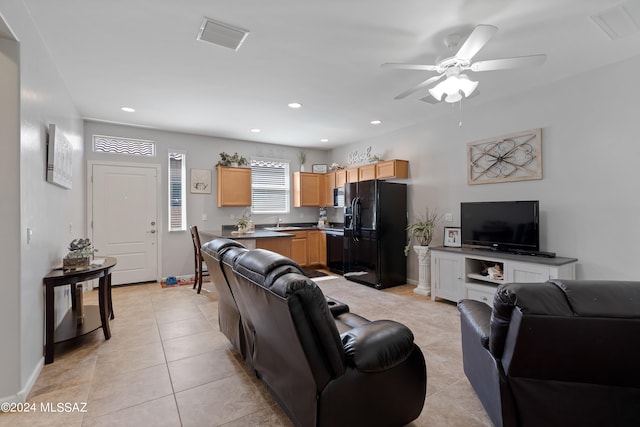 tiled living room with ceiling fan and sink