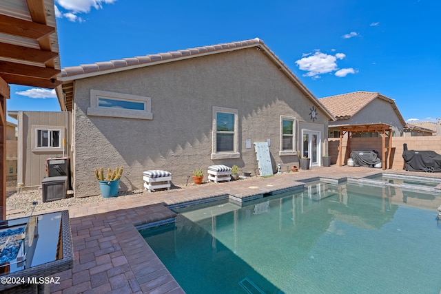 rear view of house featuring a fenced in pool and a patio