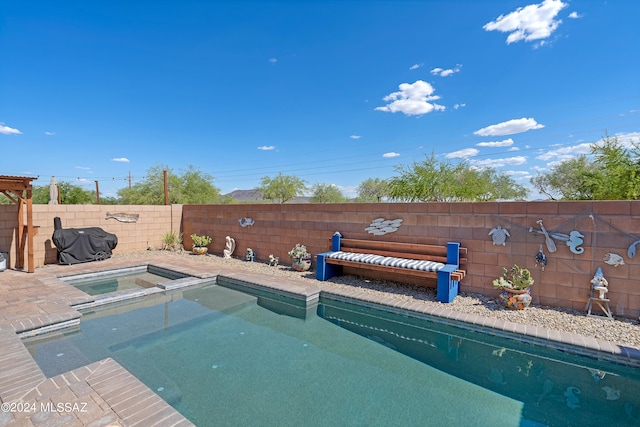 view of pool with an in ground hot tub