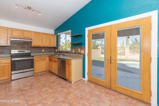 kitchen featuring sink, french doors, backsplash, stainless steel appliances, and lofted ceiling