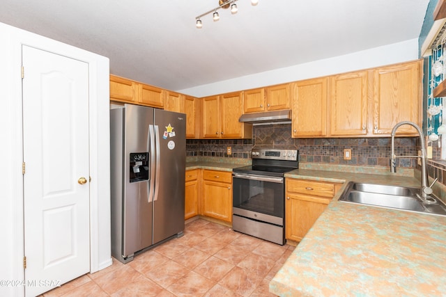 kitchen with light tile patterned floors, stainless steel appliances, tasteful backsplash, and sink