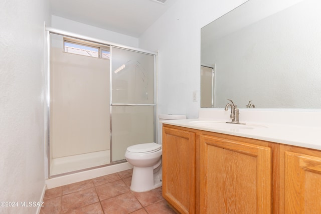 bathroom with vanity, toilet, tile patterned floors, and a shower with door