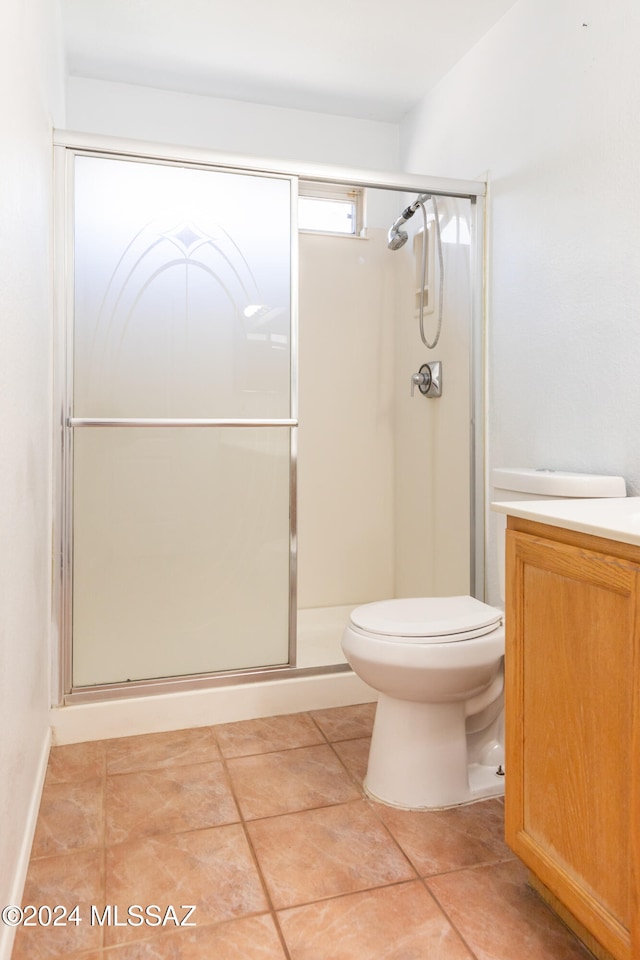 bathroom with vanity, toilet, tile patterned floors, and an enclosed shower