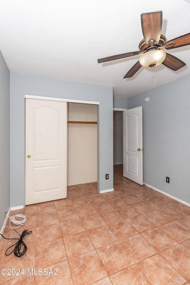 unfurnished bedroom featuring a closet, light tile patterned floors, and ceiling fan