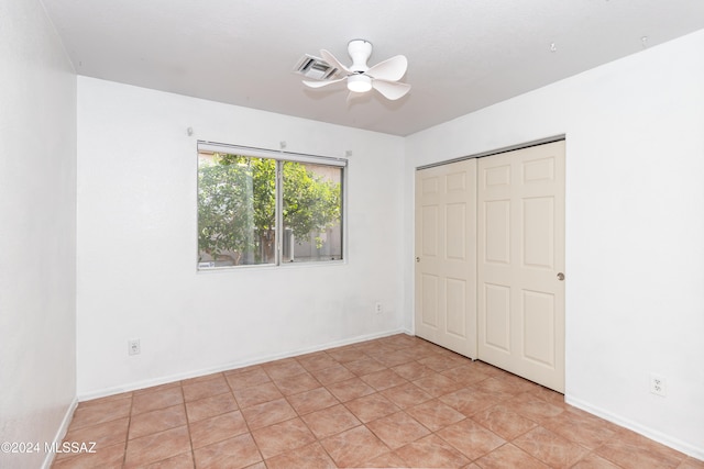 unfurnished bedroom with a closet, ceiling fan, and light tile patterned flooring