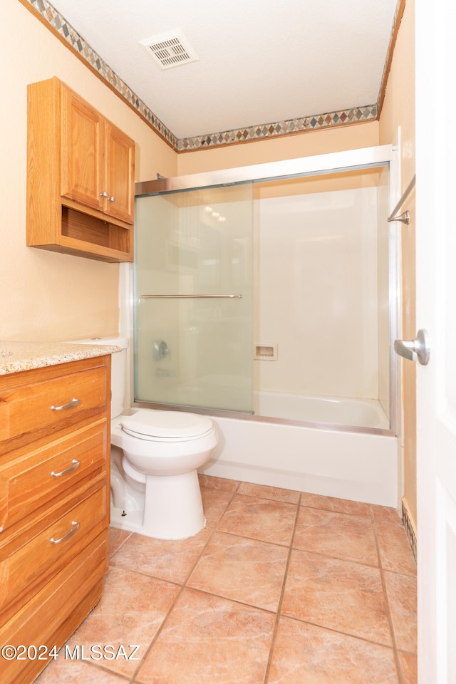 full bathroom featuring toilet, vanity, tile patterned floors, and shower / bath combination with glass door