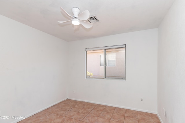 tiled spare room featuring ceiling fan