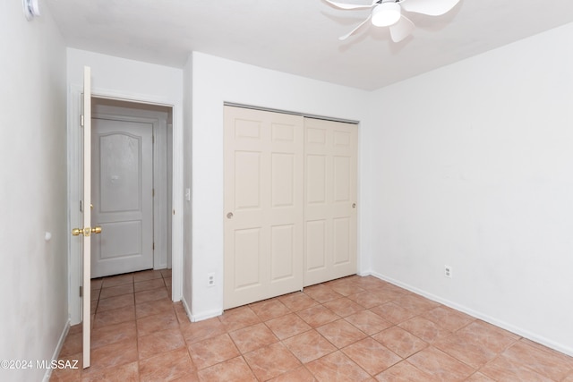 unfurnished bedroom featuring light tile patterned floors, a closet, and ceiling fan