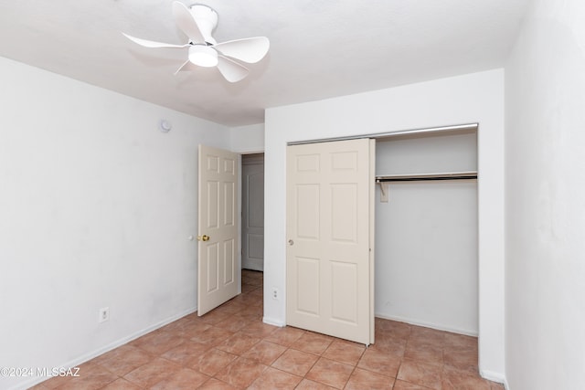 unfurnished bedroom featuring a closet, light tile patterned floors, and ceiling fan