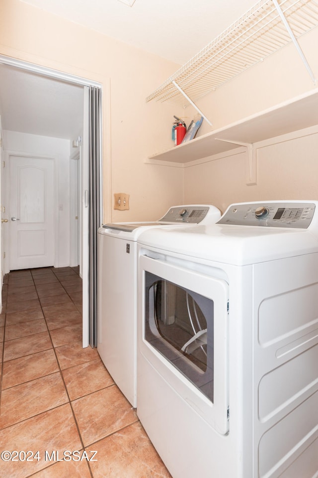 laundry area featuring washer and dryer and light tile patterned floors