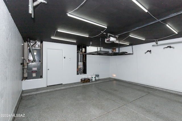 garage featuring a garage door opener, heating unit, and water heater