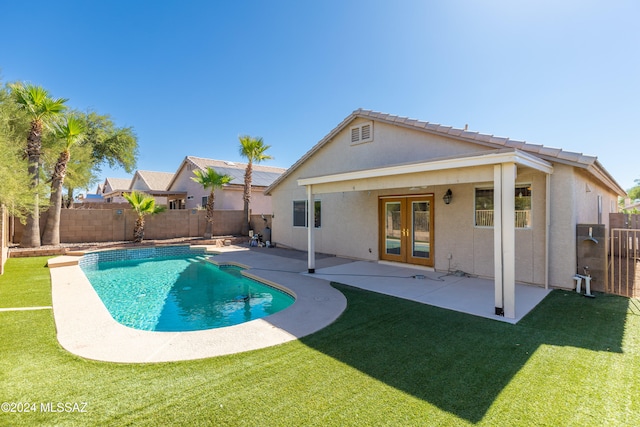 view of swimming pool featuring a patio, french doors, and a yard