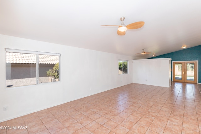 unfurnished room featuring light tile patterned flooring, plenty of natural light, and vaulted ceiling