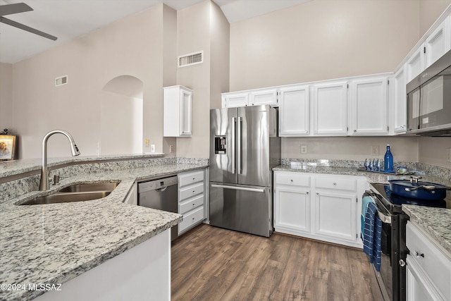 kitchen with sink, light stone counters, appliances with stainless steel finishes, dark hardwood / wood-style flooring, and white cabinetry