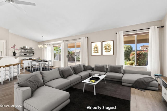 living room with light hardwood / wood-style flooring and ceiling fan with notable chandelier