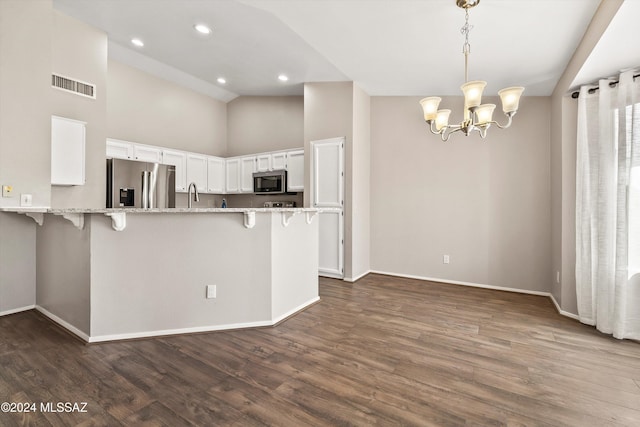 kitchen featuring pendant lighting, white cabinets, a breakfast bar area, kitchen peninsula, and stainless steel appliances