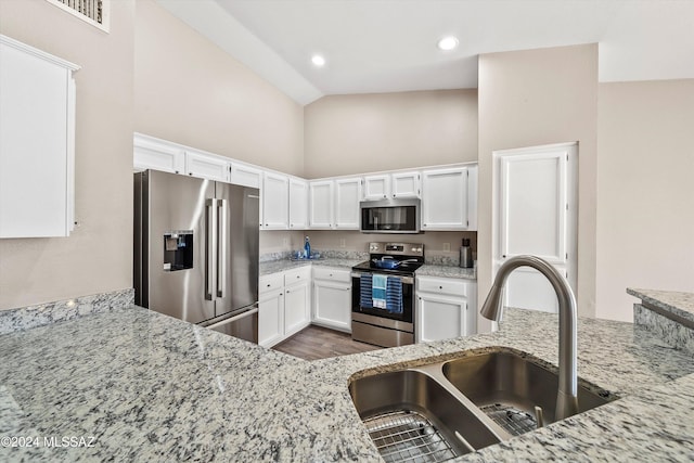 kitchen featuring light stone countertops, sink, high vaulted ceiling, white cabinets, and appliances with stainless steel finishes