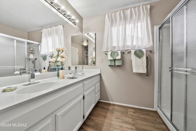 bathroom featuring wood-type flooring, vanity, and walk in shower