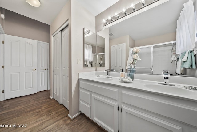 bathroom with vanity, hardwood / wood-style flooring, and a shower with shower door